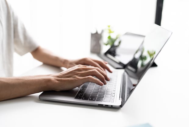 a person participating in an online consultation using their laptop