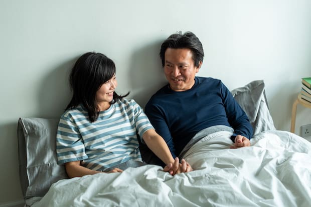 a couple sitting in bed together
