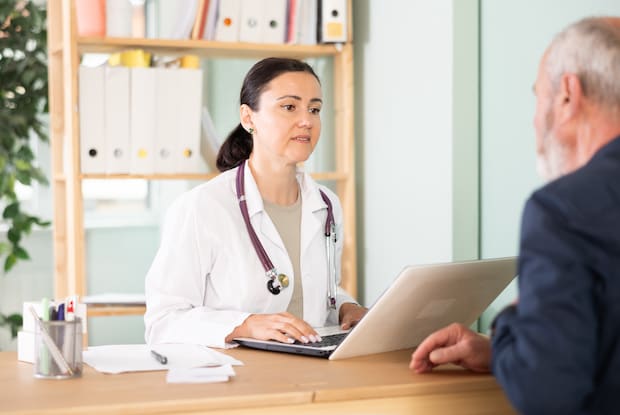 a pharmacist speaking to an elderly man