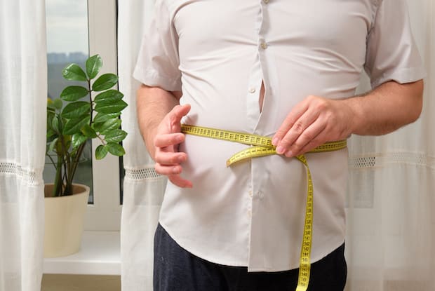 a man measuring himself with a measuring tape