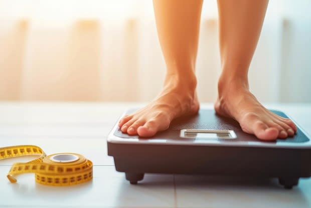 a person on weight loss treatment standing on a weighing scale