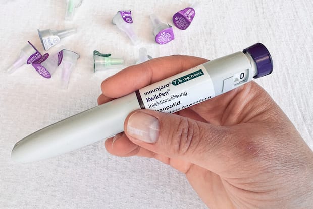 a hand holding a Mounjaro pen