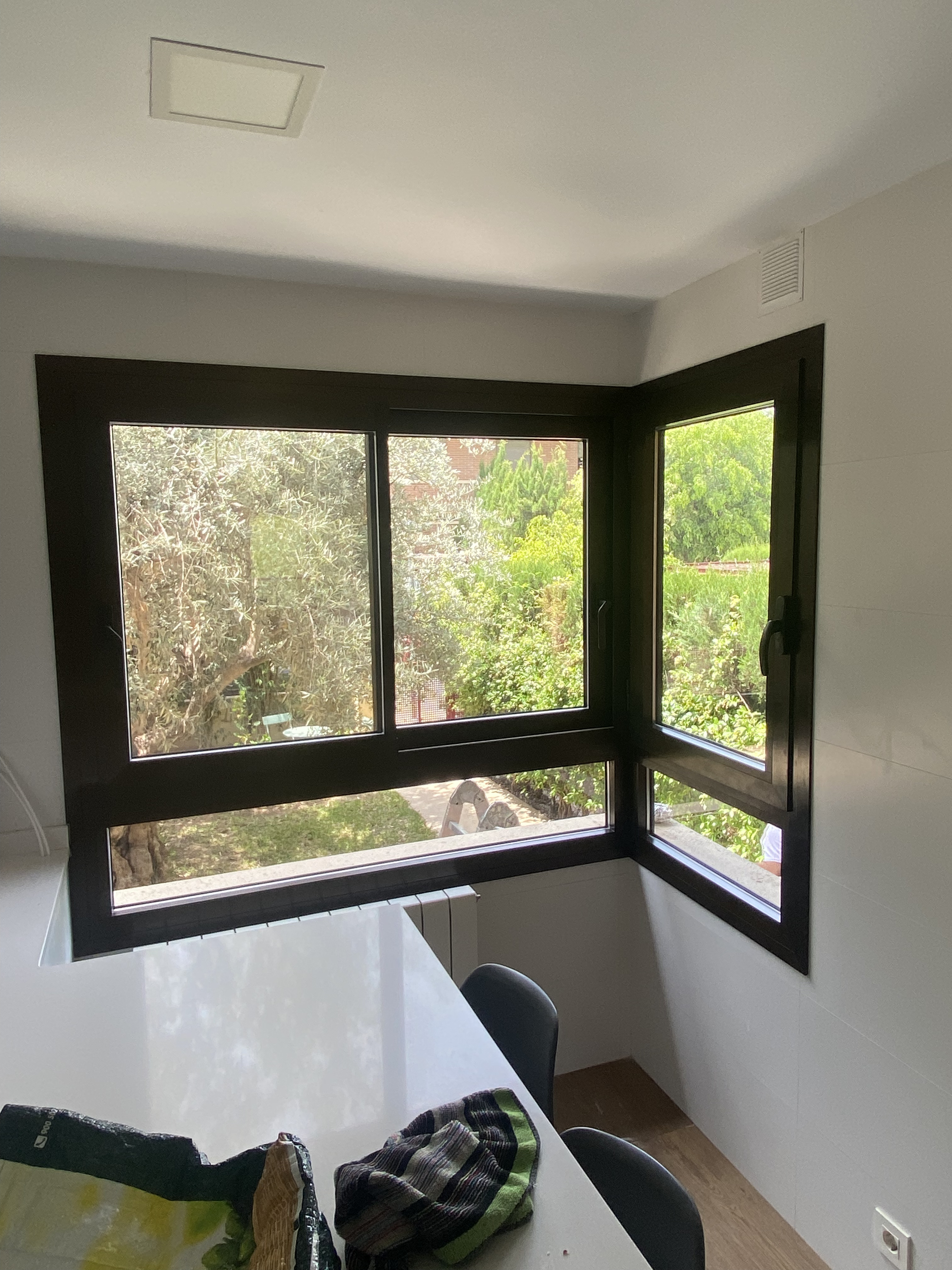 Ventanas de aluminio en esquina con vistas al jardín en cocina de vivienda en Alicante  