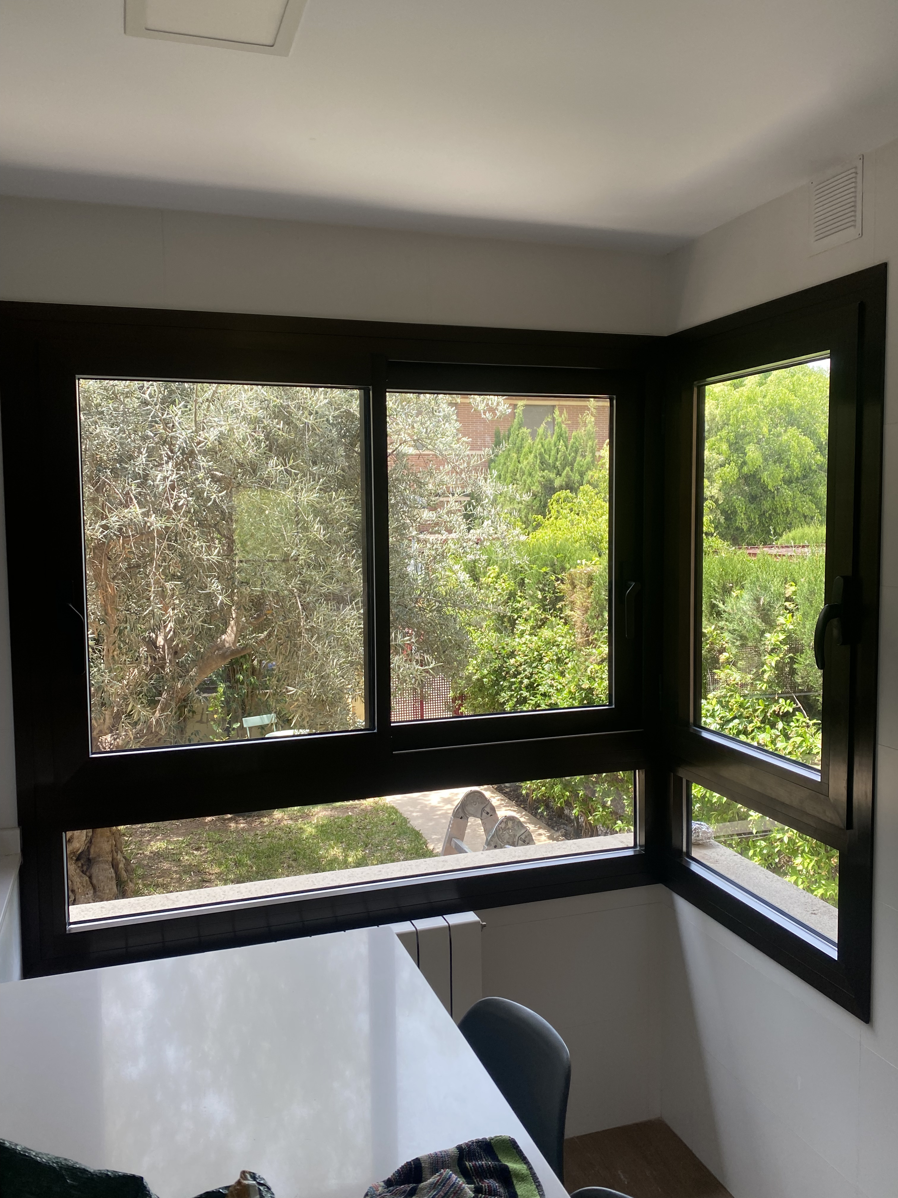 Ventanas de aluminio en esquina con vistas al jardín en cocina de vivienda en Alicante  