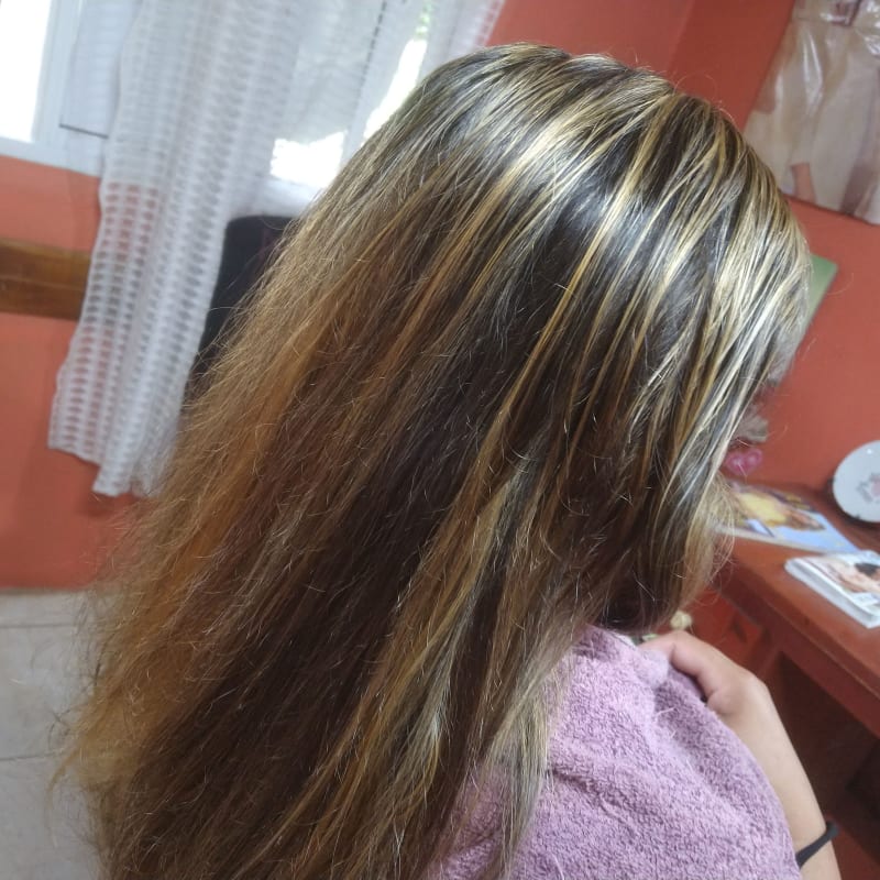 Mechas rubias finas en cabello largo castaño