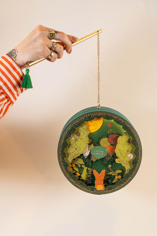 main tenant un coffret lanterne illustré Lady M Mid-Autumn 2024