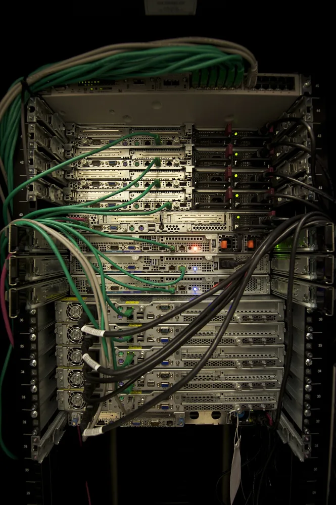 Plusieurs serveurs informatiques empilés dans une baie avec des câbles connectés.