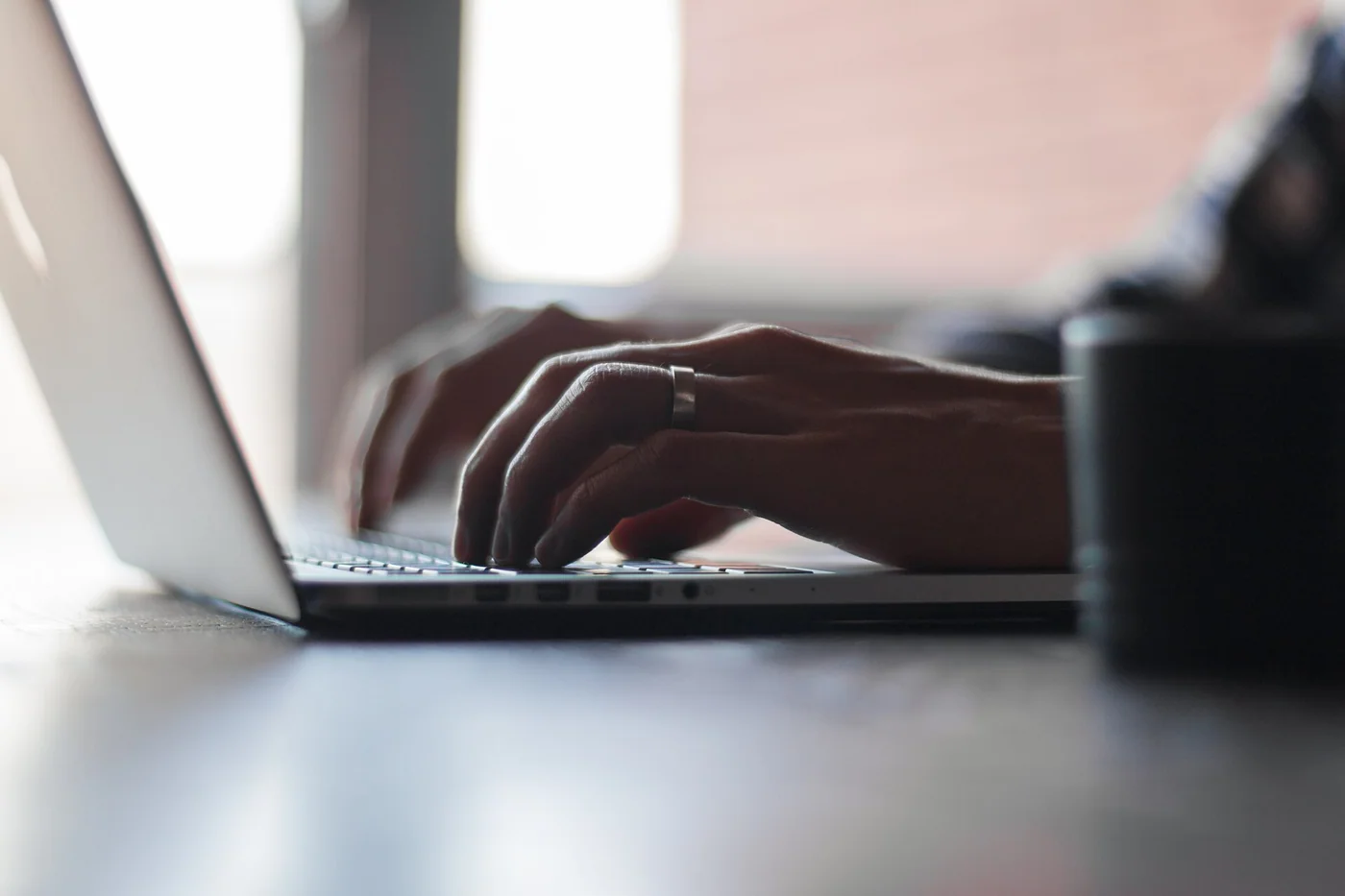 Des mains saisissent du texte sur un ordinateur portable