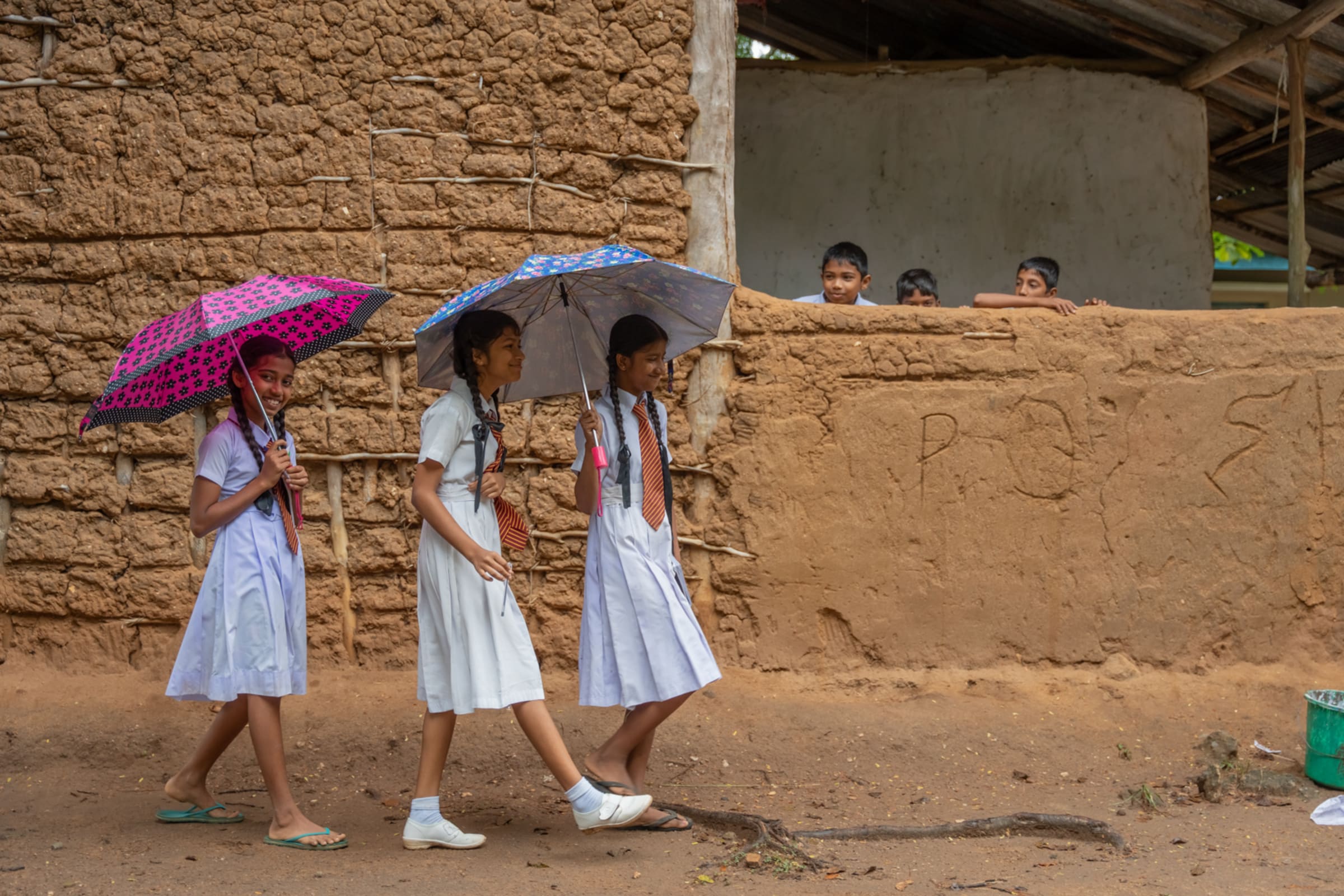 Schoolchildren walking with umbrellas in Sri Lanka, photographed by InceptChange