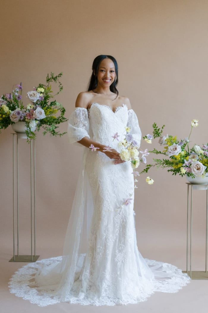 Bride wearing lace trumpet gown with off-the-shoulder tulle sleeves