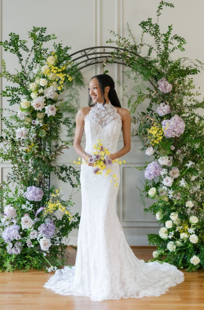 High-neck lace fit-and-flare gown with a form-fitting silhouette and intricate floral details.