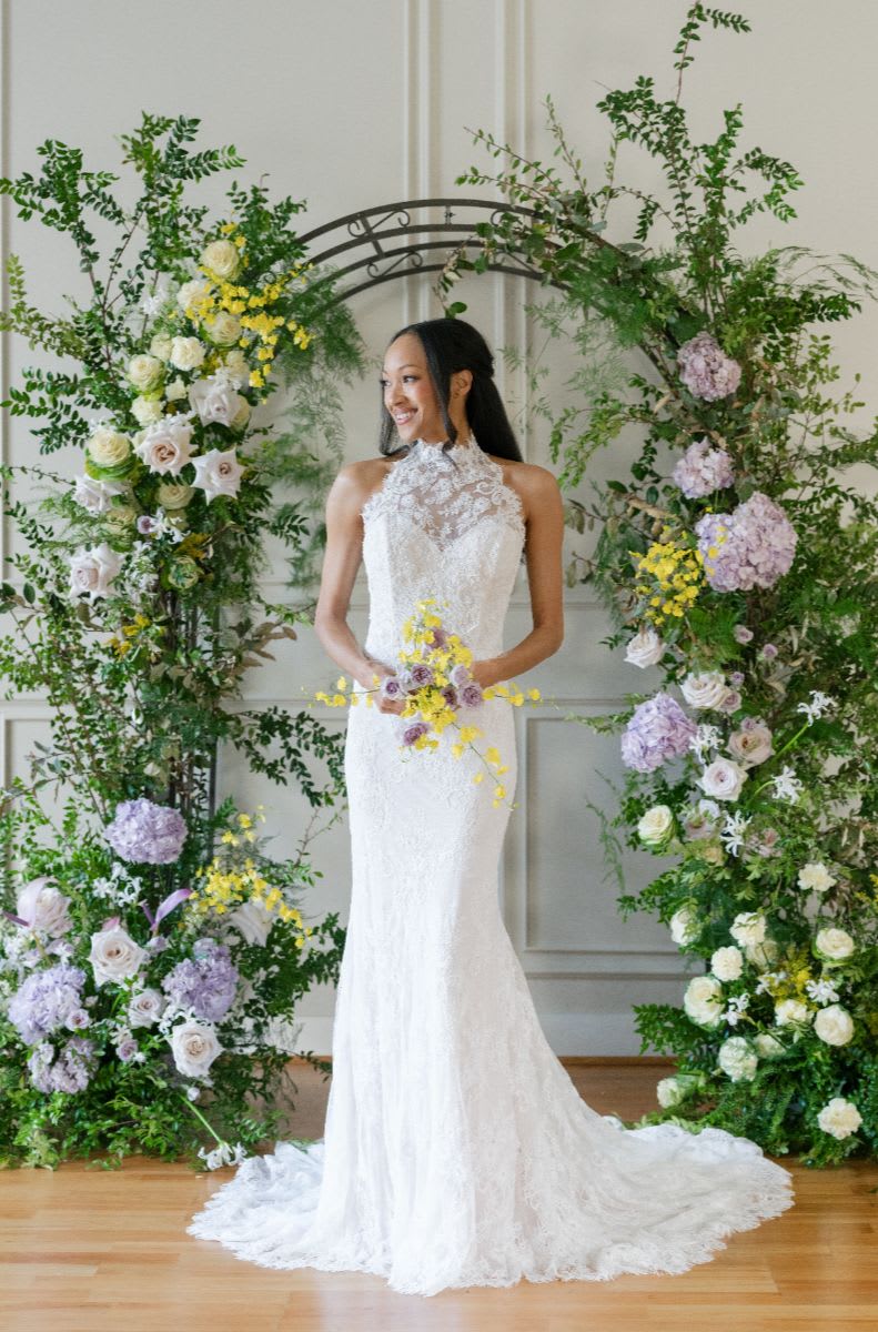 High-neck lace fit-and-flare gown with a form-fitting silhouette and intricate floral details. 