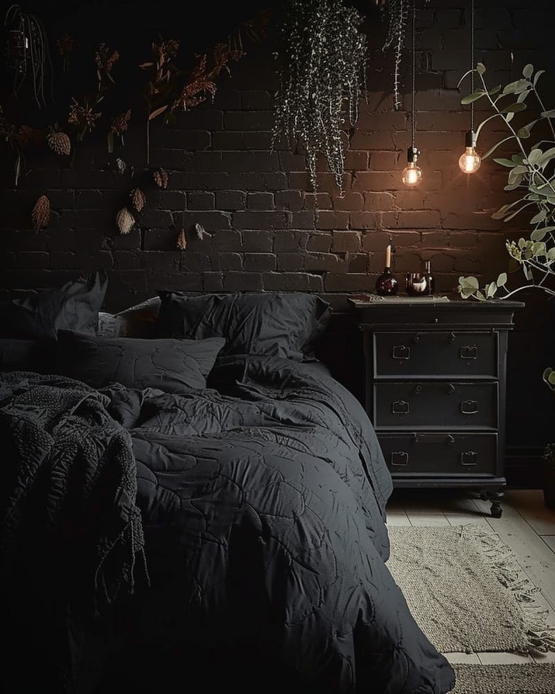 Gothic dark bedroom featuring black brick walls, dried botanicals, Edison bulb lighting, vintage dresser, textured bedding, natural jute rug, and moody botanical design