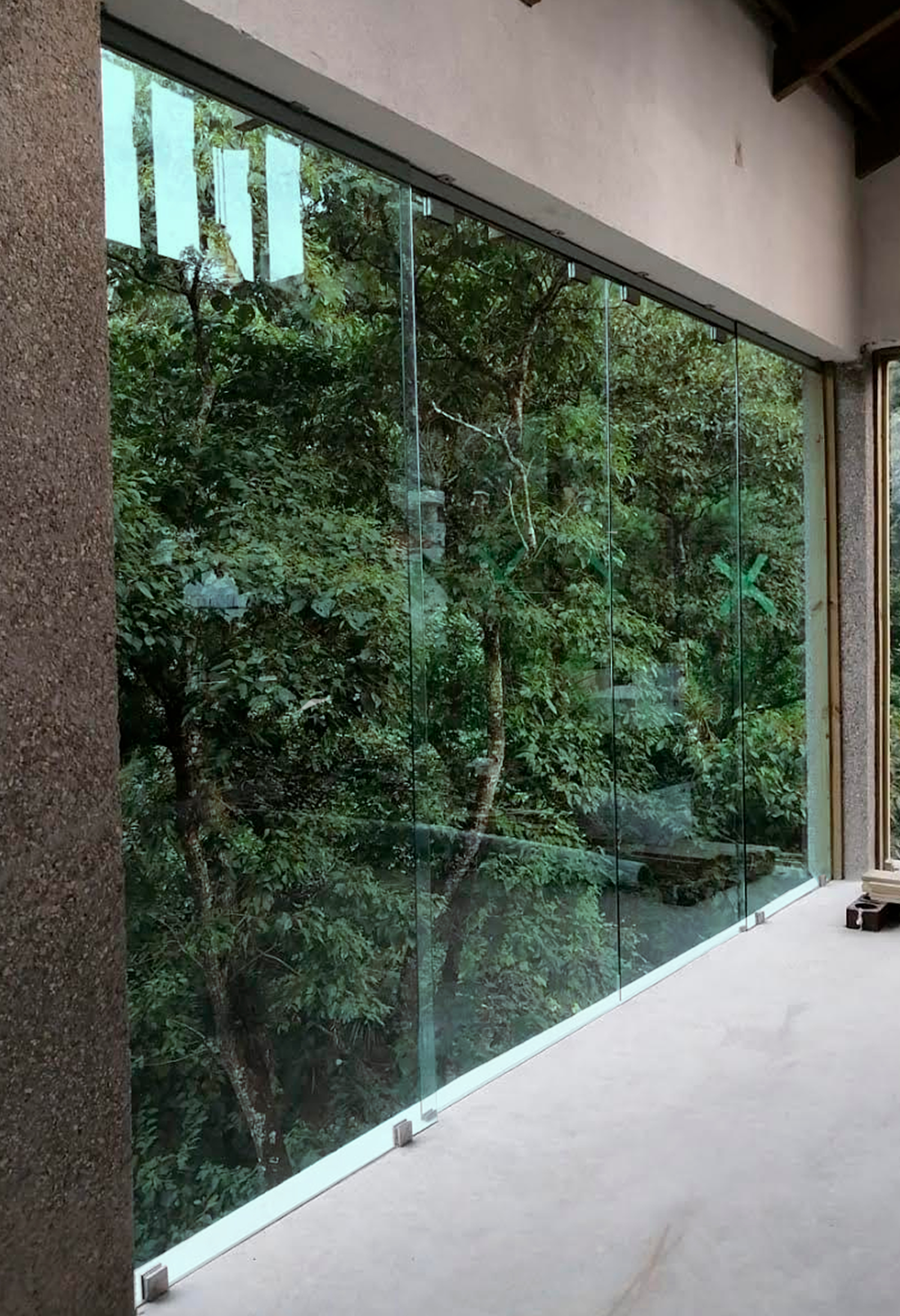Fachada de vidrio templado con vista al jardín