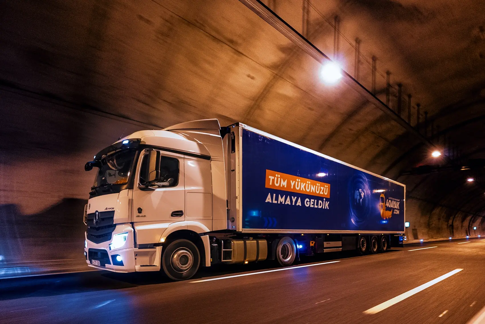 40Ayak’a ait bir tırın üstünde ‘Tüm Yükünü Almaya Geldik’ yazılı slogan ile tünel otoyolda seyir halindedir.