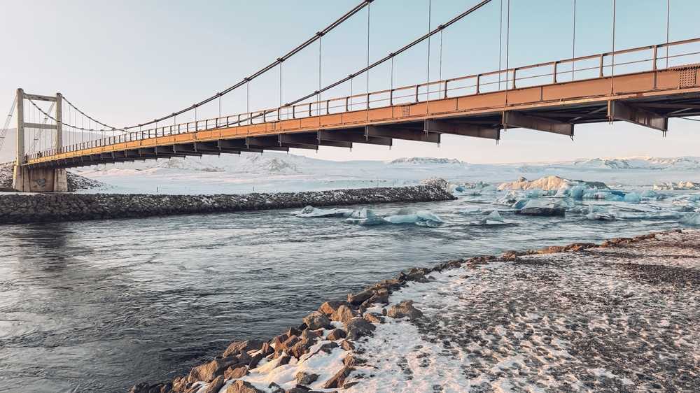 Bridge crossing an icy glacier lagoon in Iceland during winter