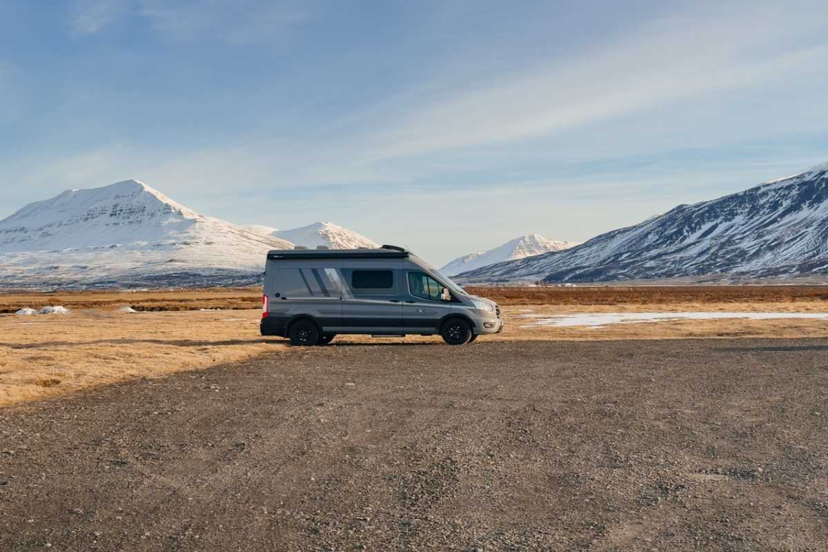 Motorhome parked on an Icelandic road between snow-covered mountains.