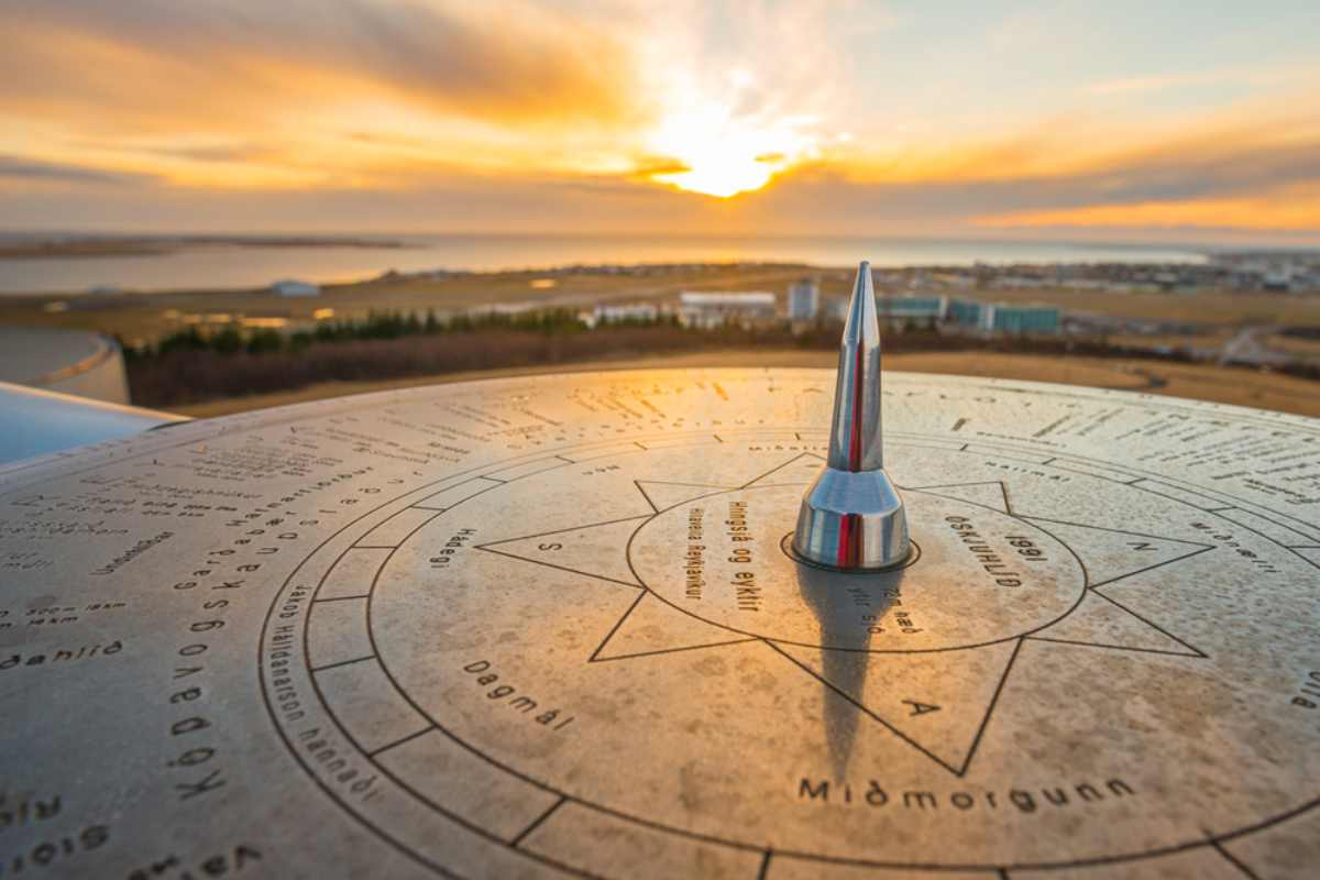 Viewpoint compass overlooking Reykjavík and the Icelandic coastline at sunset.