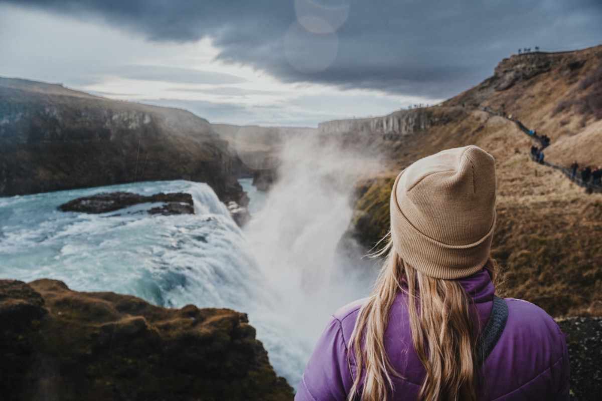 Reisender, der den Gullfoss-Wasserfall von einem Aussichtspunkt in Island aus betrachtet.