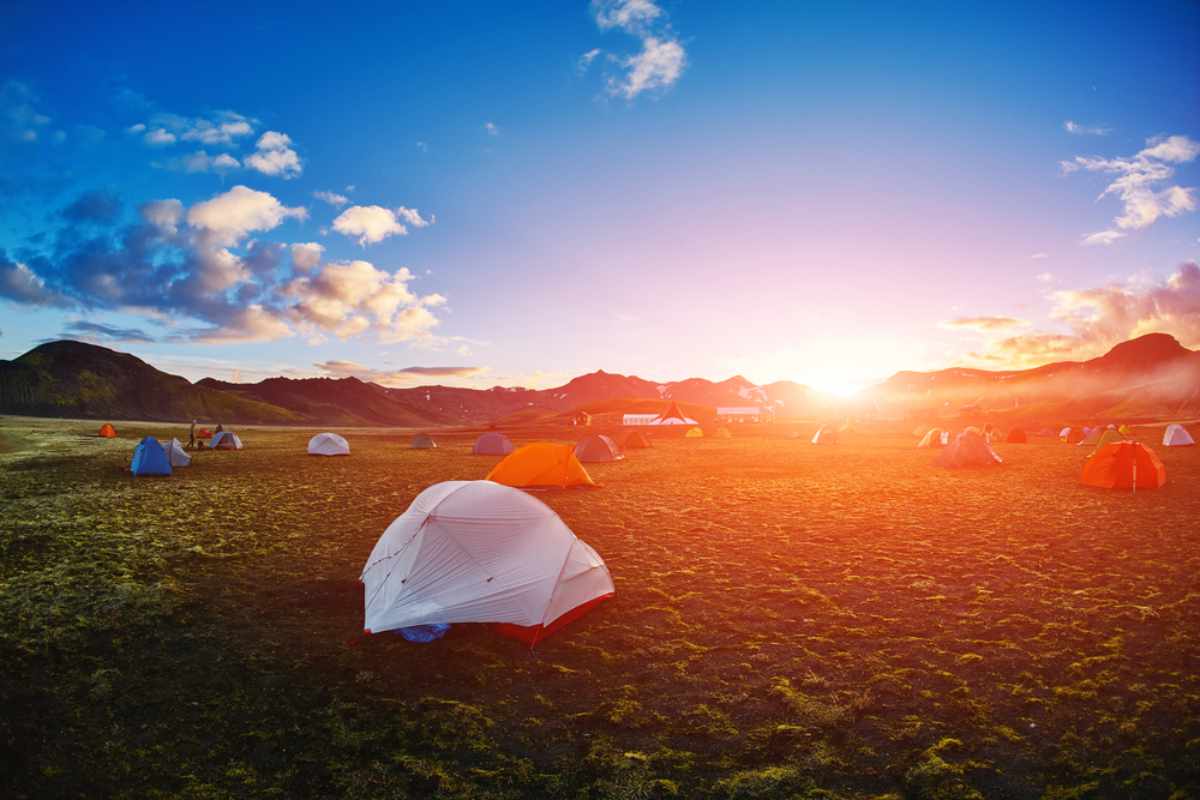 Zelte, die bei Sonnenuntergang auf einem isländischen Campingplatz aufgestellt sind.