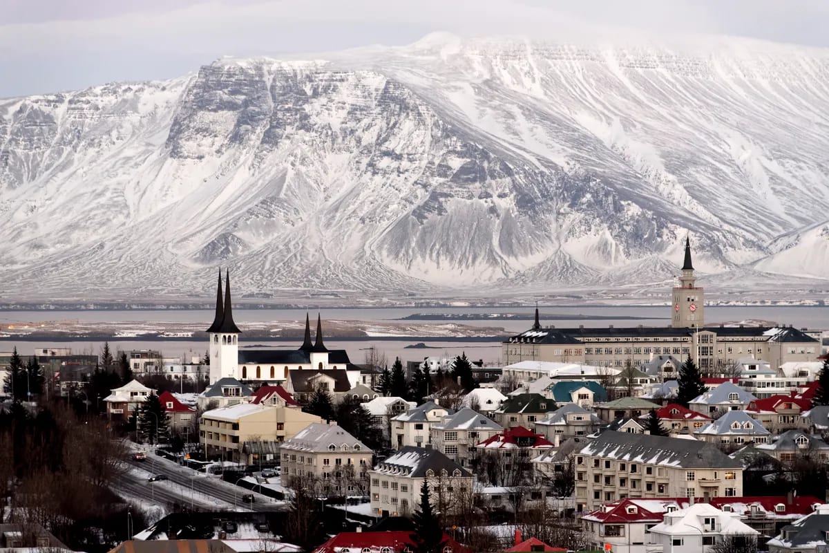 Panoramic view of Reykjavik in December with Hallgrimskirkja, colorful rooftops and snow-covered mountains beneath a winter sky