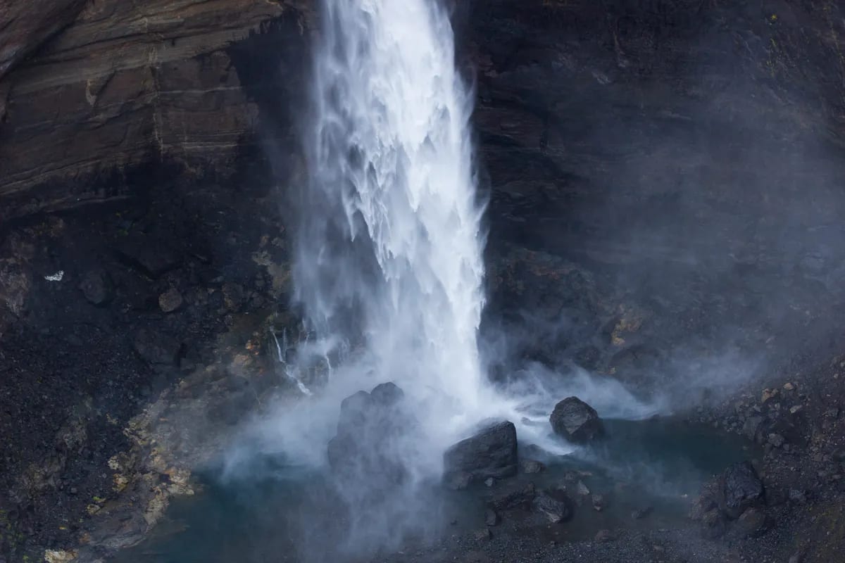 Close-up of Haifoss waterfall crashing into a misty turquoise pool, surrounded by dark canyon rocks in Iceland’s Þjórsárdalur valley