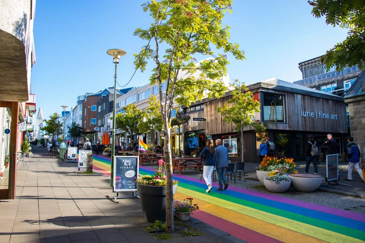 Pedestrians stroll along Reykjavik’s colorful Rainbow Street lined with shops, cafés and galleries, a lively downtown stop in Iceland’s capital