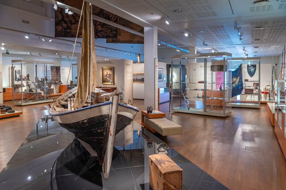 Traditional Icelandic fishing boat displayed inside a Reykjavik maritime museum, with historic artifacts and exhibits for November visitors