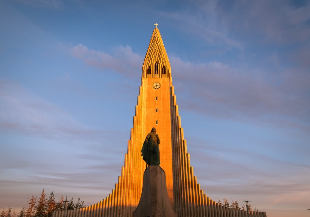 Hallgrímskirkja church glows at sunset in Reykjavík, with Leif Erikson statue and autumn sky for an Iceland September city guide.