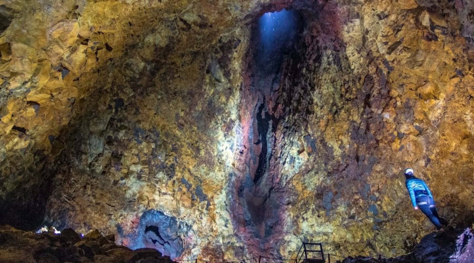 Visitor inside a colorful volcanic chamber on an inside the volcano tour from Reykjavik