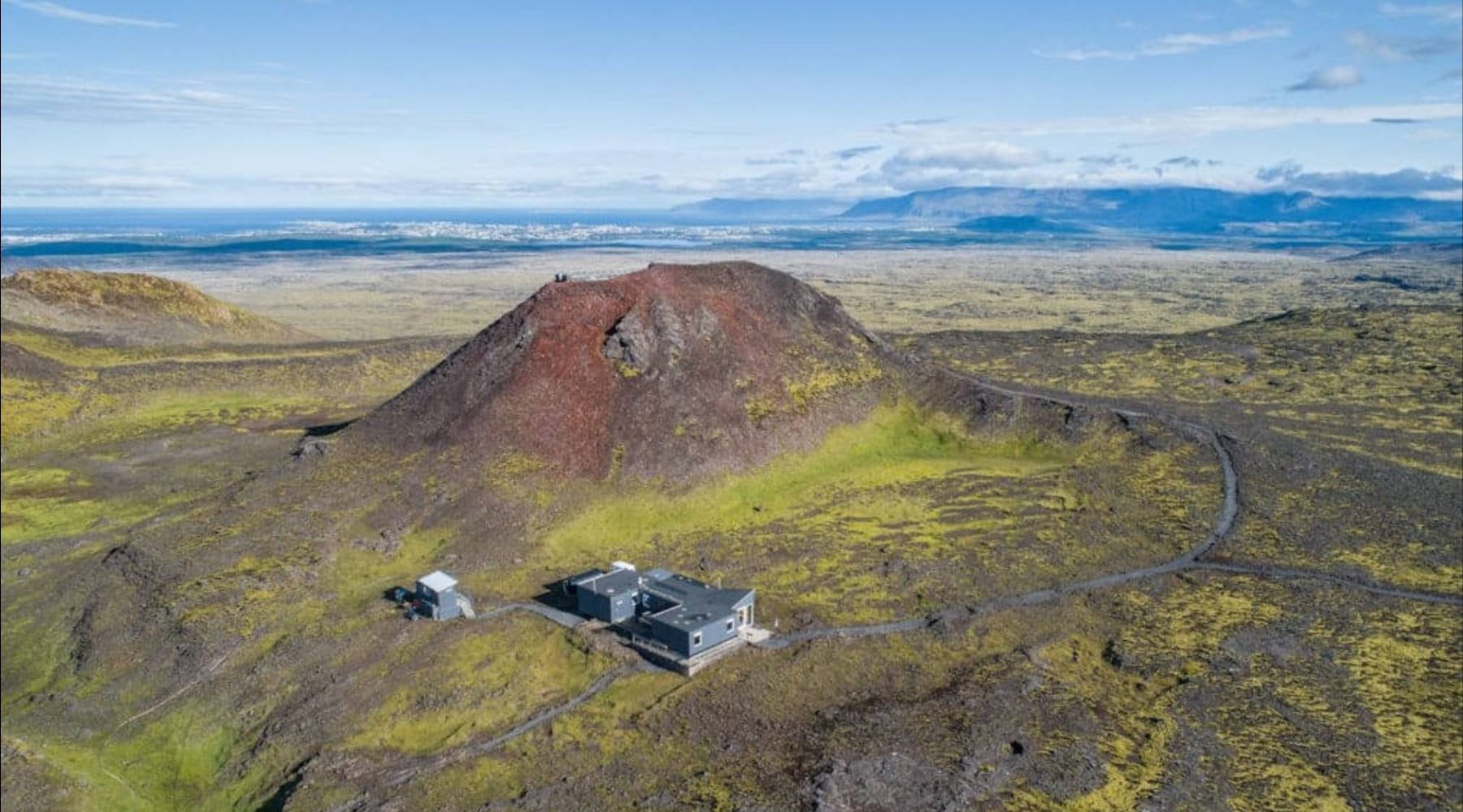 Aerial view of a volcanic crater surrounded by mossy lava fields near Reykjavik