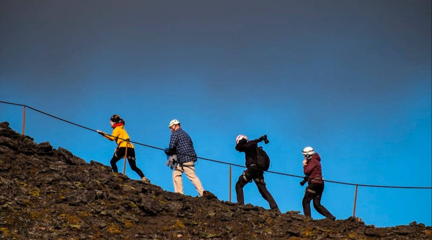 Travelers hiking up a rocky volcanic slope during an inside the volcano tour in Iceland