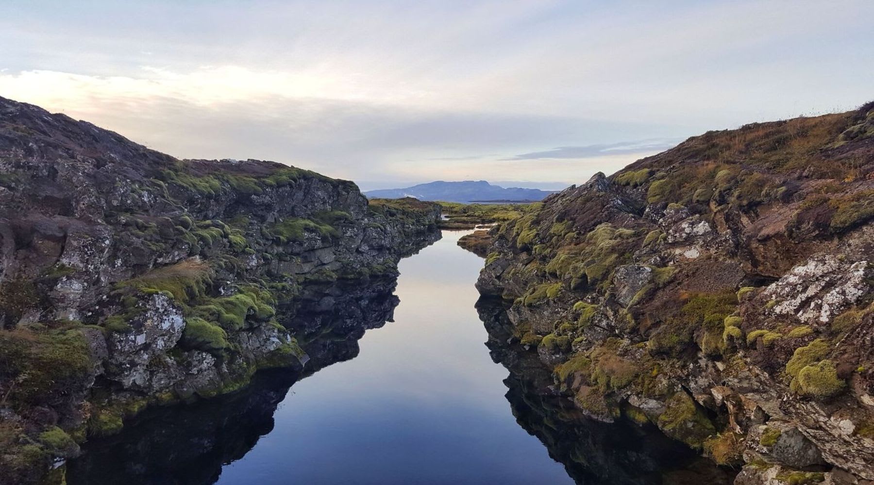 Calm water channel between mossy rocks at Silfra in Thingvellir National Park