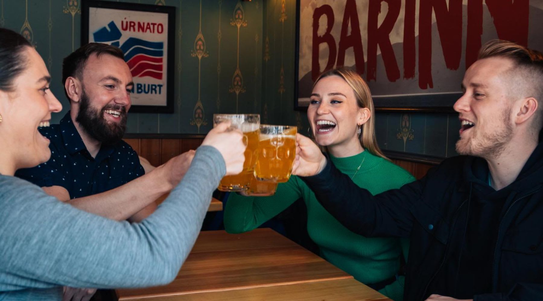 Eine Gruppe von Menschen stößt mit isländischem Bier an.