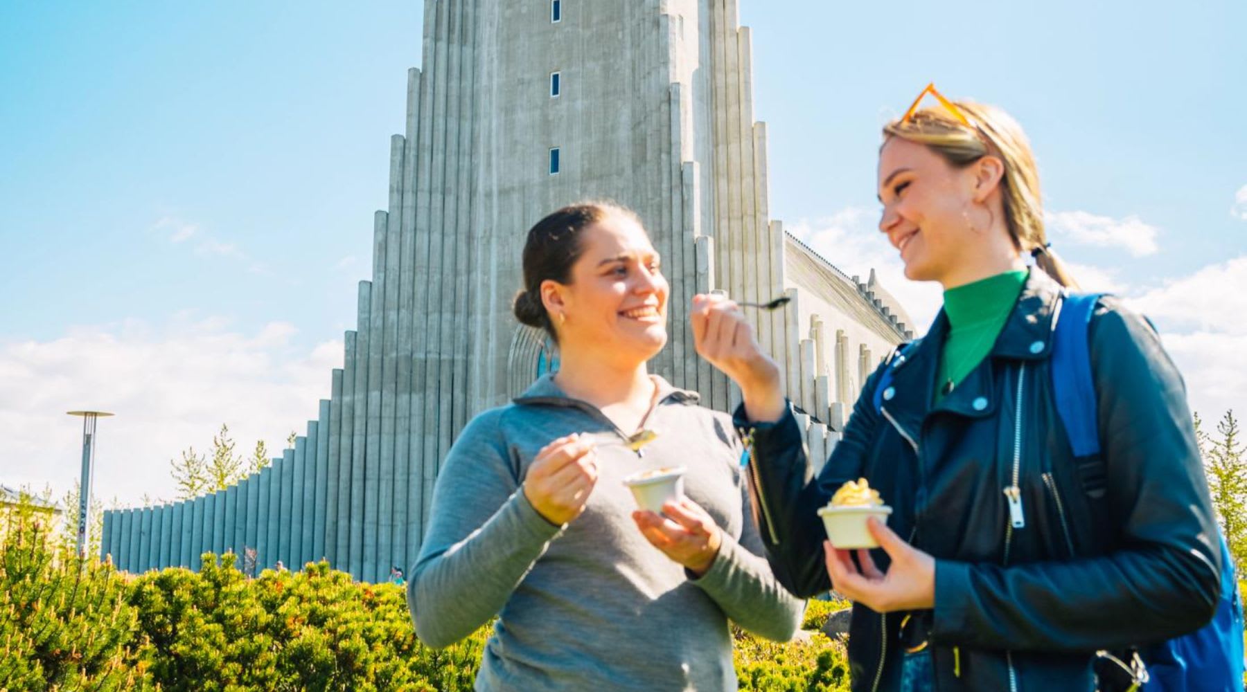 Zwei Mädchen essen Eis vor der Hallgrímskirkja Kirche in Reykjavik.