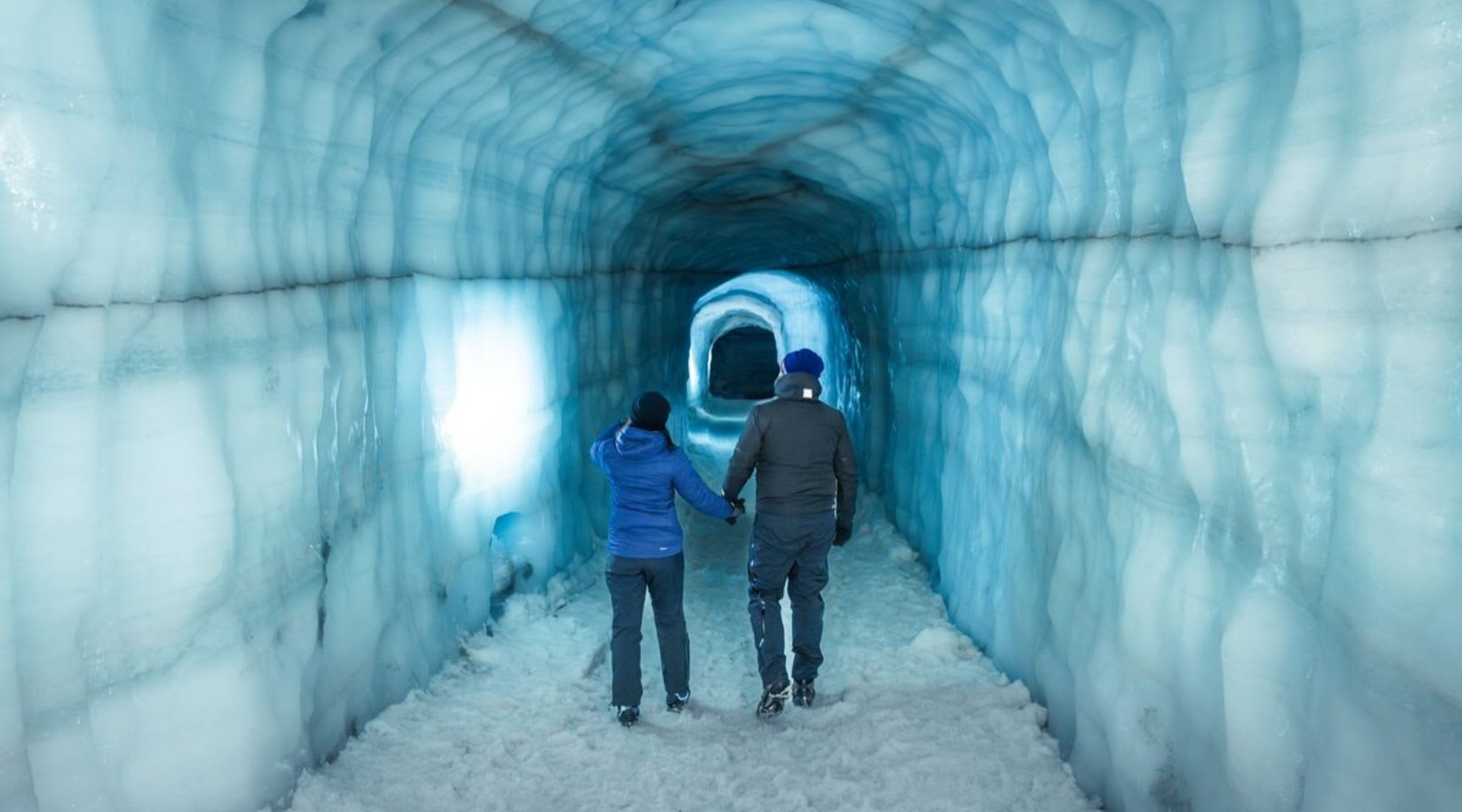Due turisti che si godono un tunnel di ghiaccio in Islanda.
