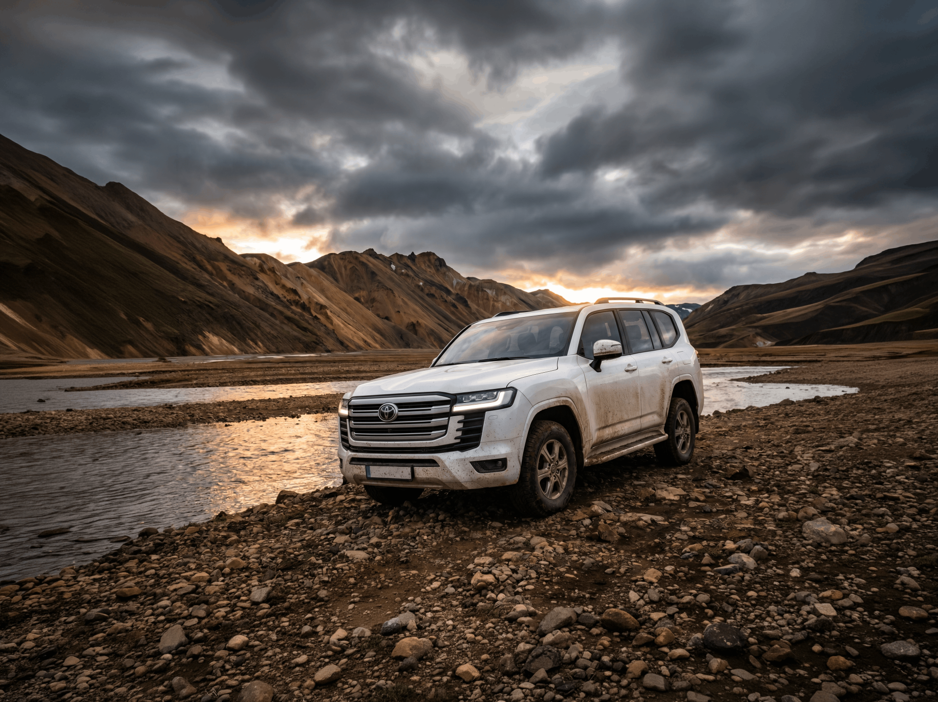 Hvid 4x4-SUV parkeret ved siden af en sø med bjerge i baggrunden under en skyet himmel