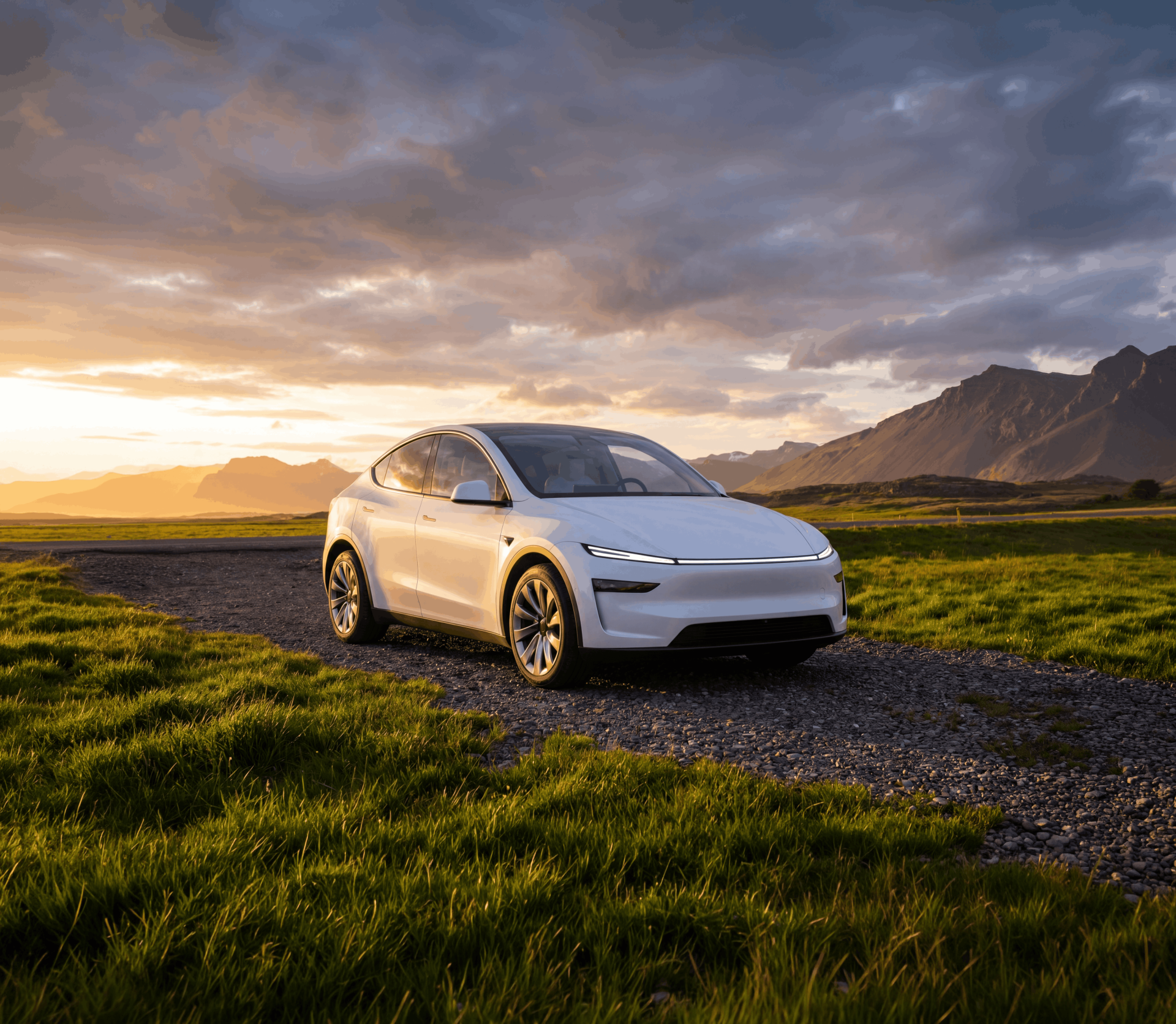 Witte elektrische auto geparkeerd op een grindpad met groene velden en heuvels bij zonsopgang