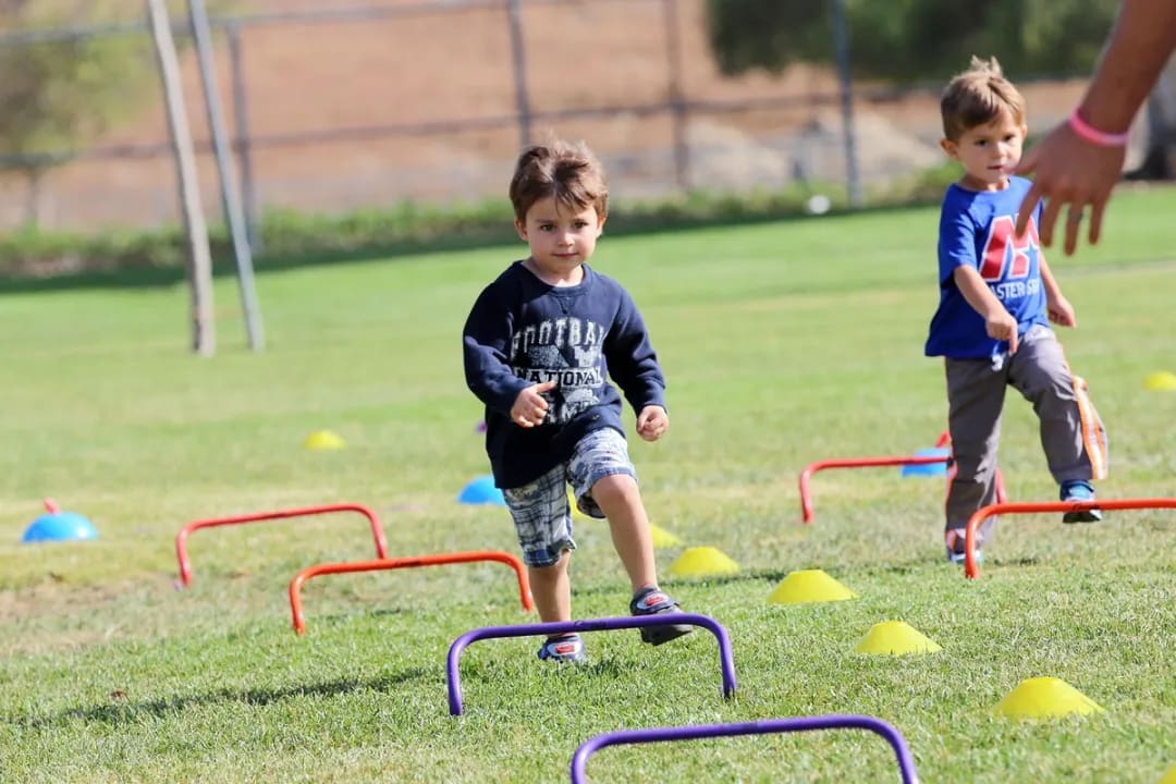 A group of kids running on a grass field