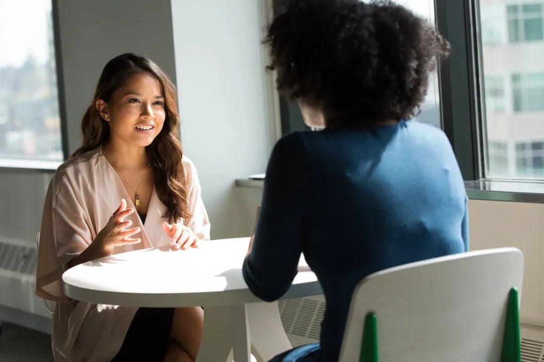Two colleagues talking at a coffee table