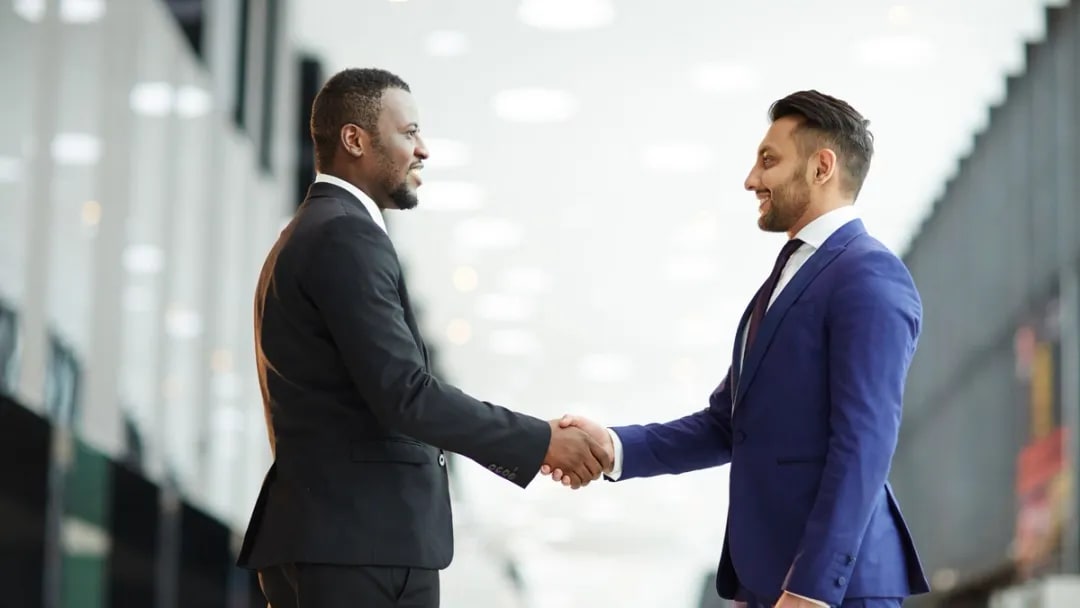 Two men in suits shaking hands