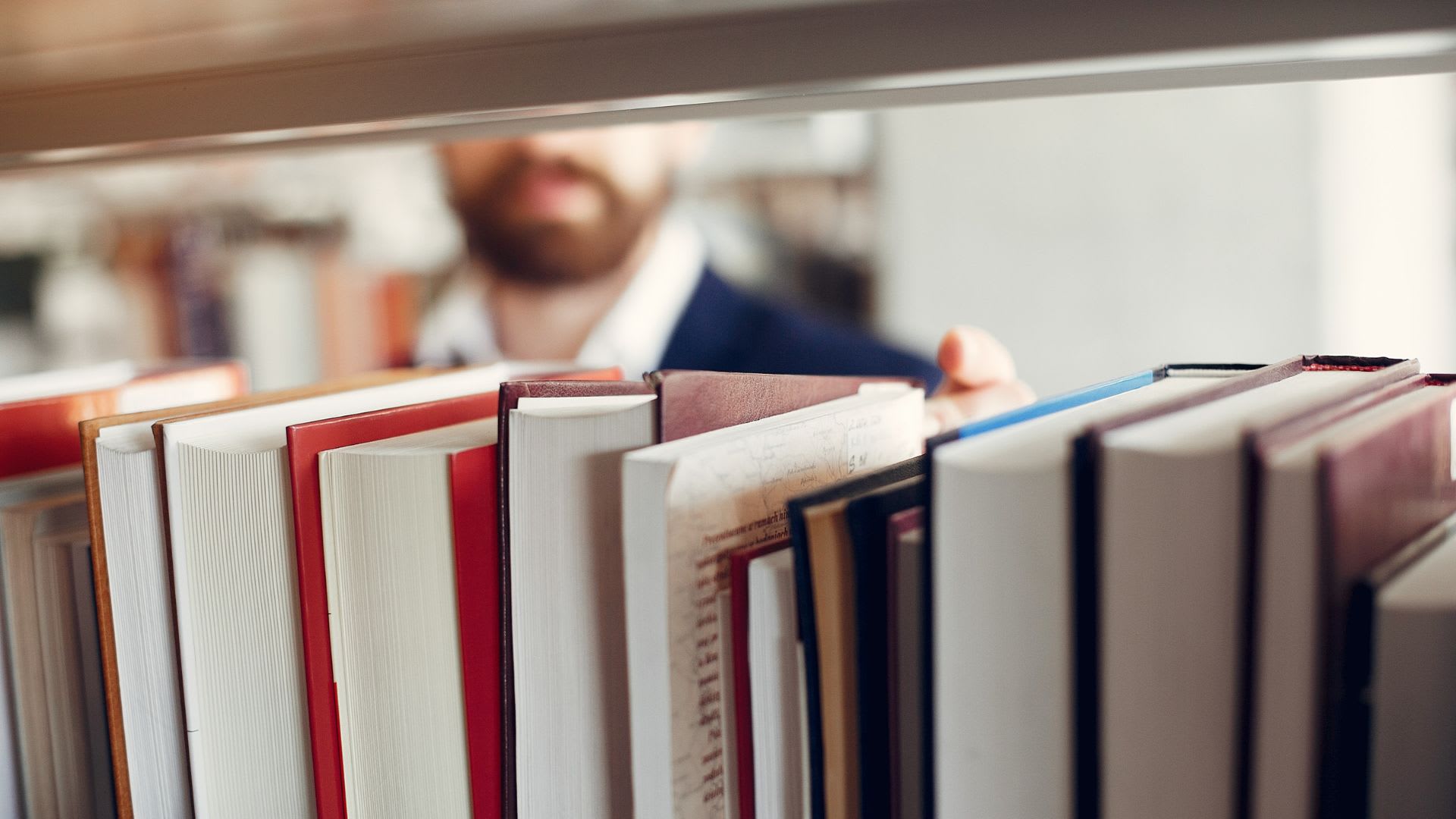 A man browsing through a bookshelf at a library