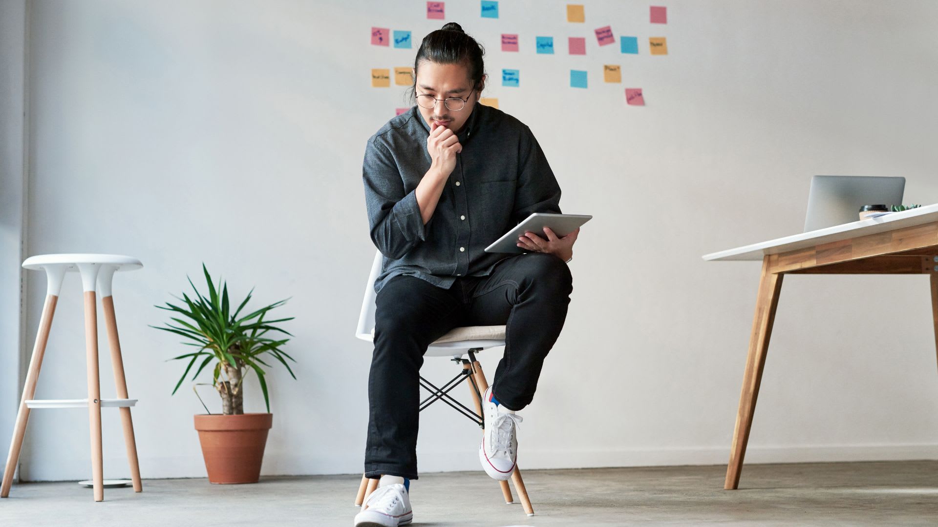 a person sitting on a chair with a tablet