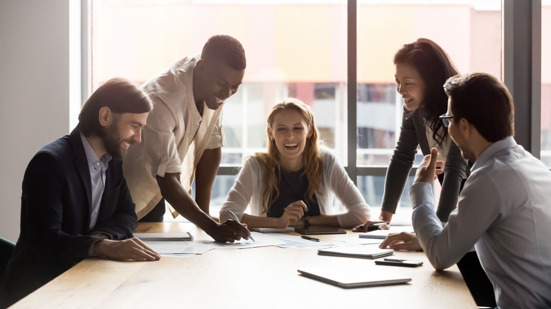 A diverse team collaborating on a project in a vibrant office environment, symbolizing enhanced teamwork and employee engagement.