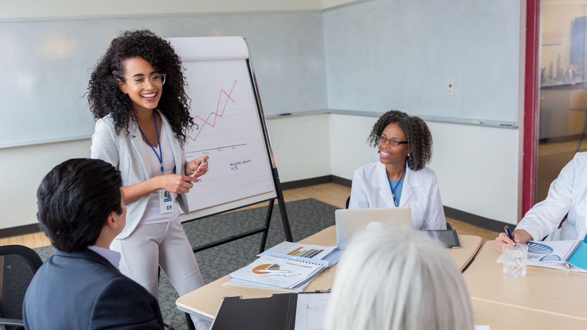 A dynamic female leader inspiring her team in a meeting, highlighting the influence of positive leadership on workplace morale.