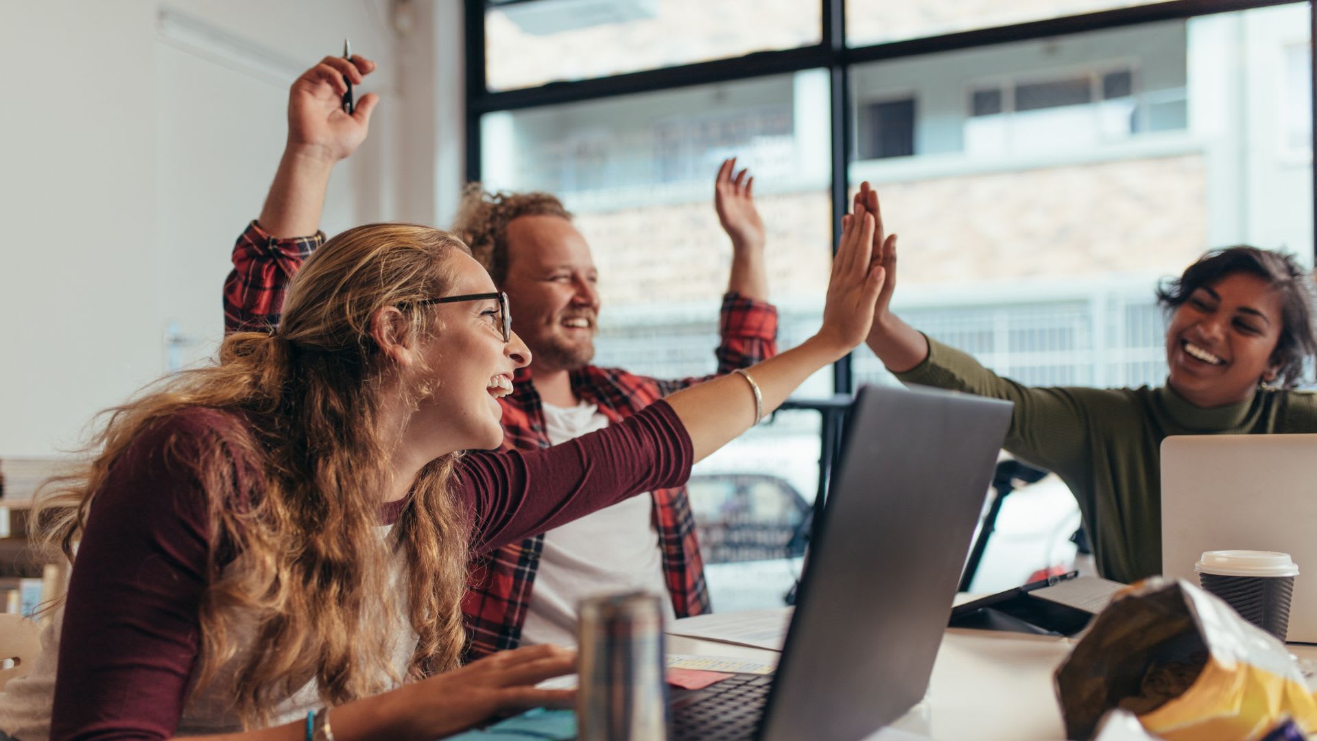 A team celebrating a milestone with performance metrics in the background, showcasing the connection between employee productivity and business success.
