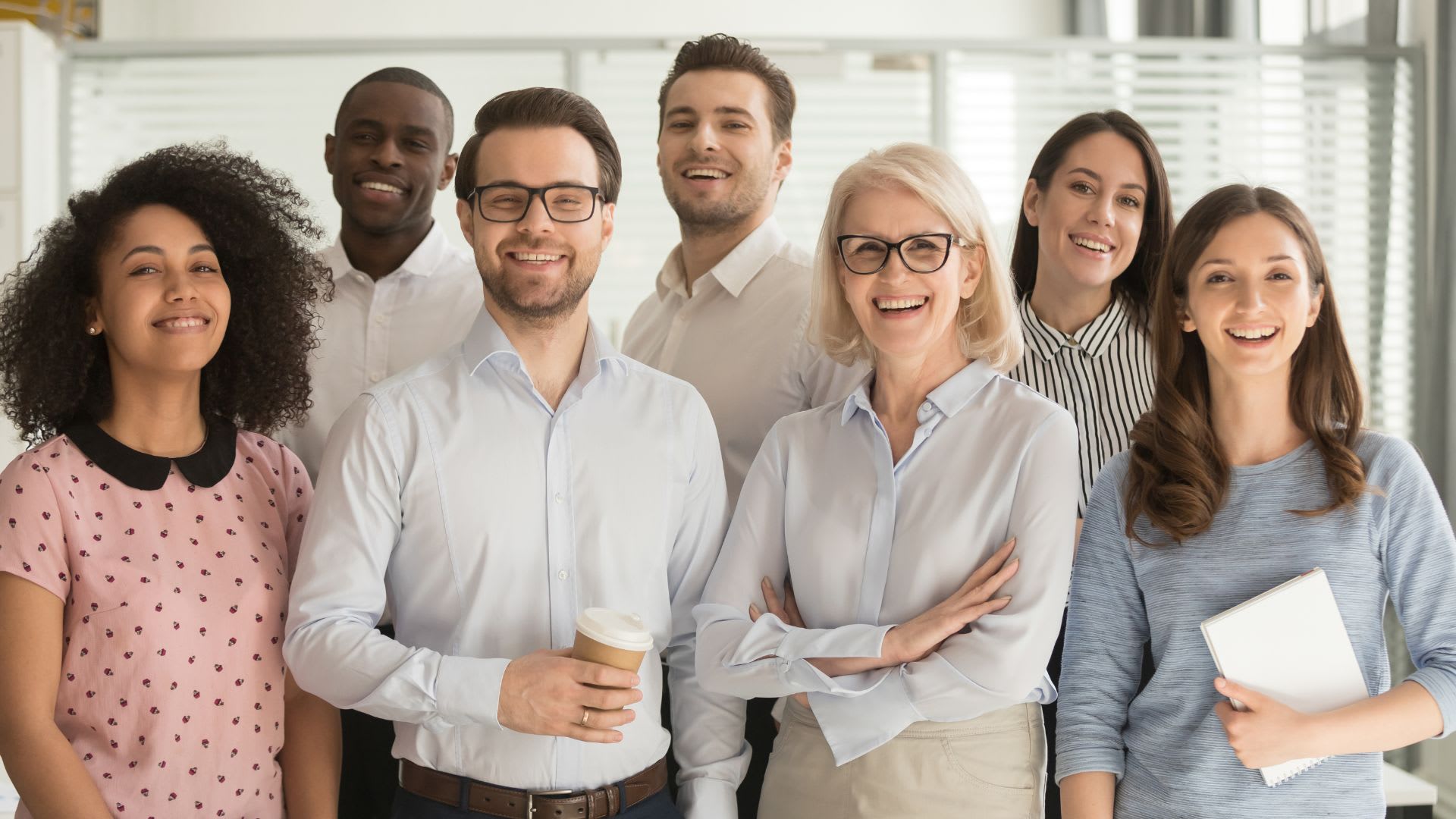 Smiling business professionals standing together in an office environment.