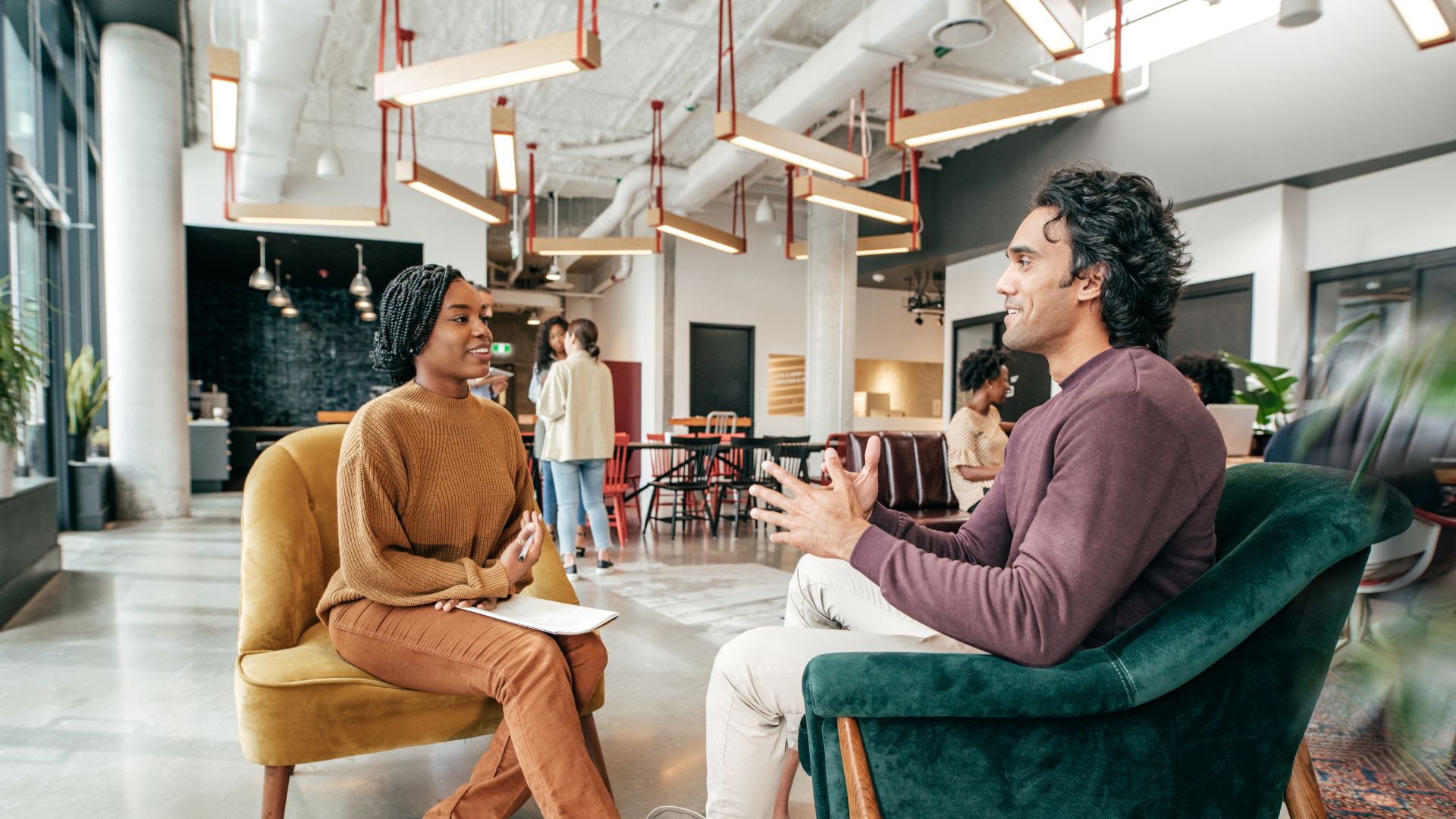 Two professionals having a discussion in an office setting.