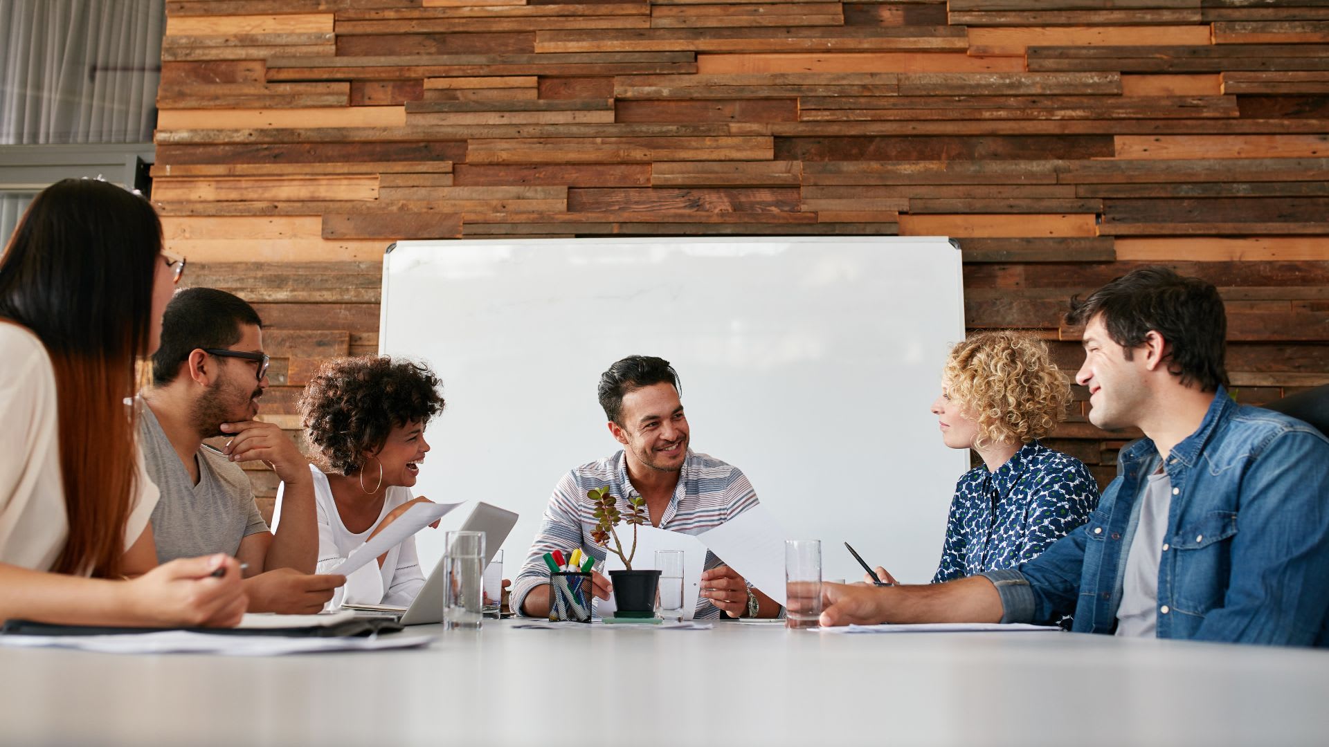 A diverse team of professionals discussing ideas and collaborating at a conference table in an office setting.