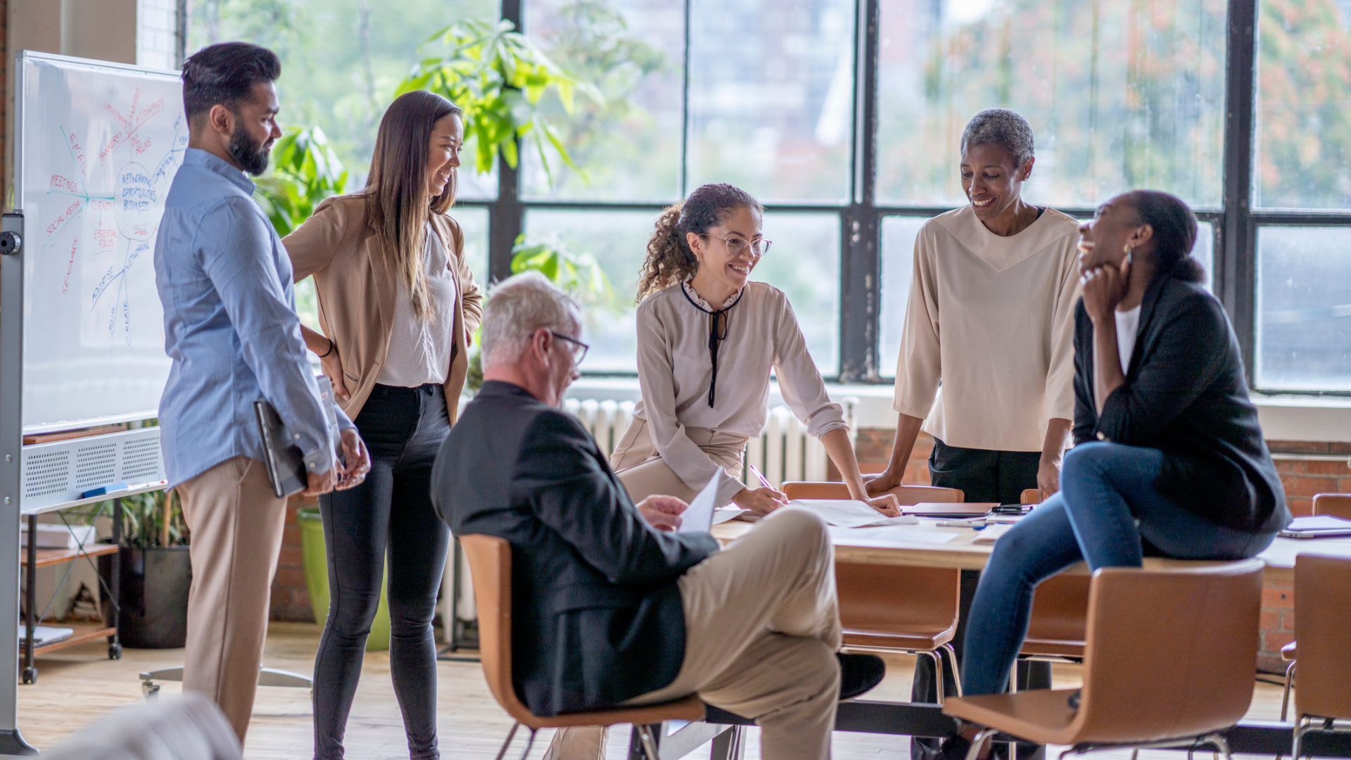 A diverse group of professionals engaged in a productive office meeting, discussing ideas and collaborating on projects.